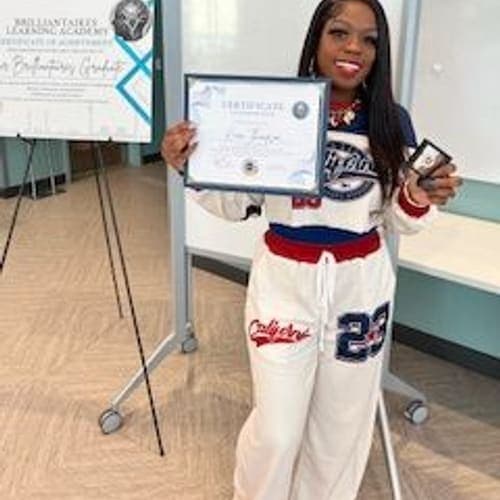 A Brilliantaires graduate celebrating with her certificate