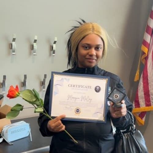 A Brilliantaires graduate holding her certificate